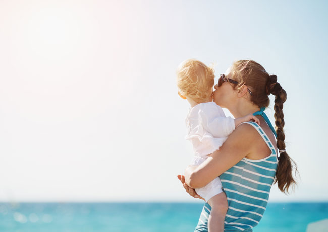 Madre con bebé en la playa Madre con bebé en la playa